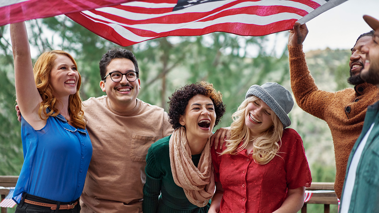 6 friends having a laugh and waving an American Flag