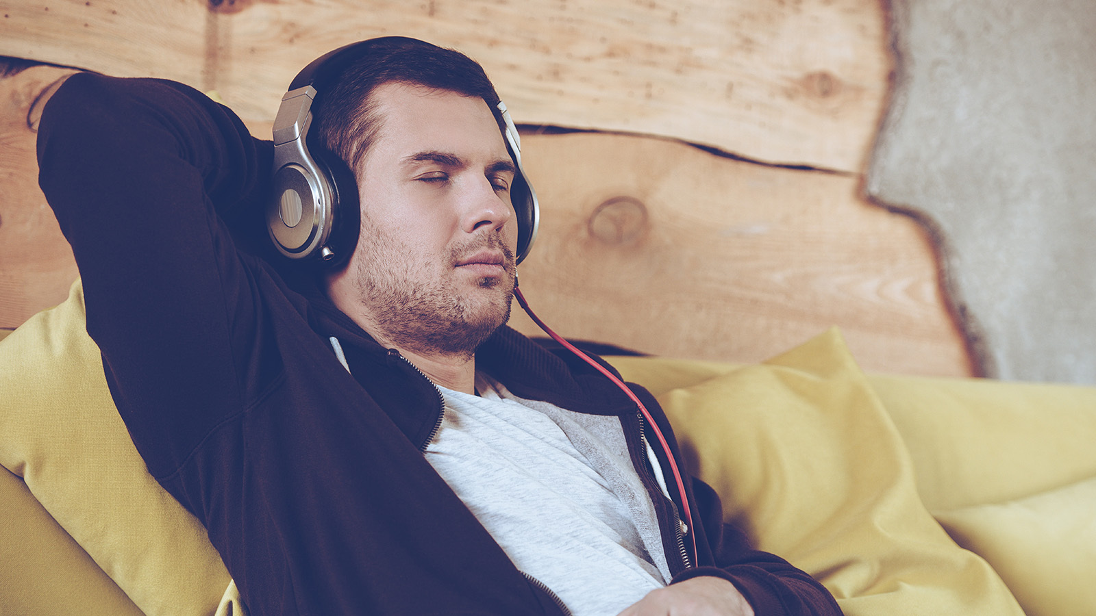 man relaxes with headphones on