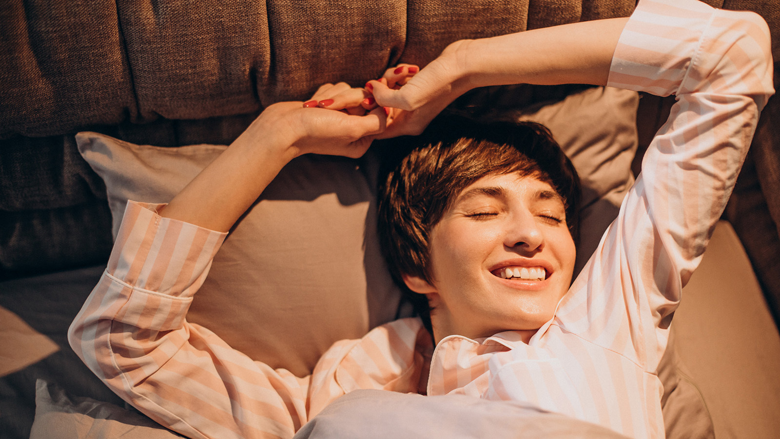 A young woman stretching as she wakes up