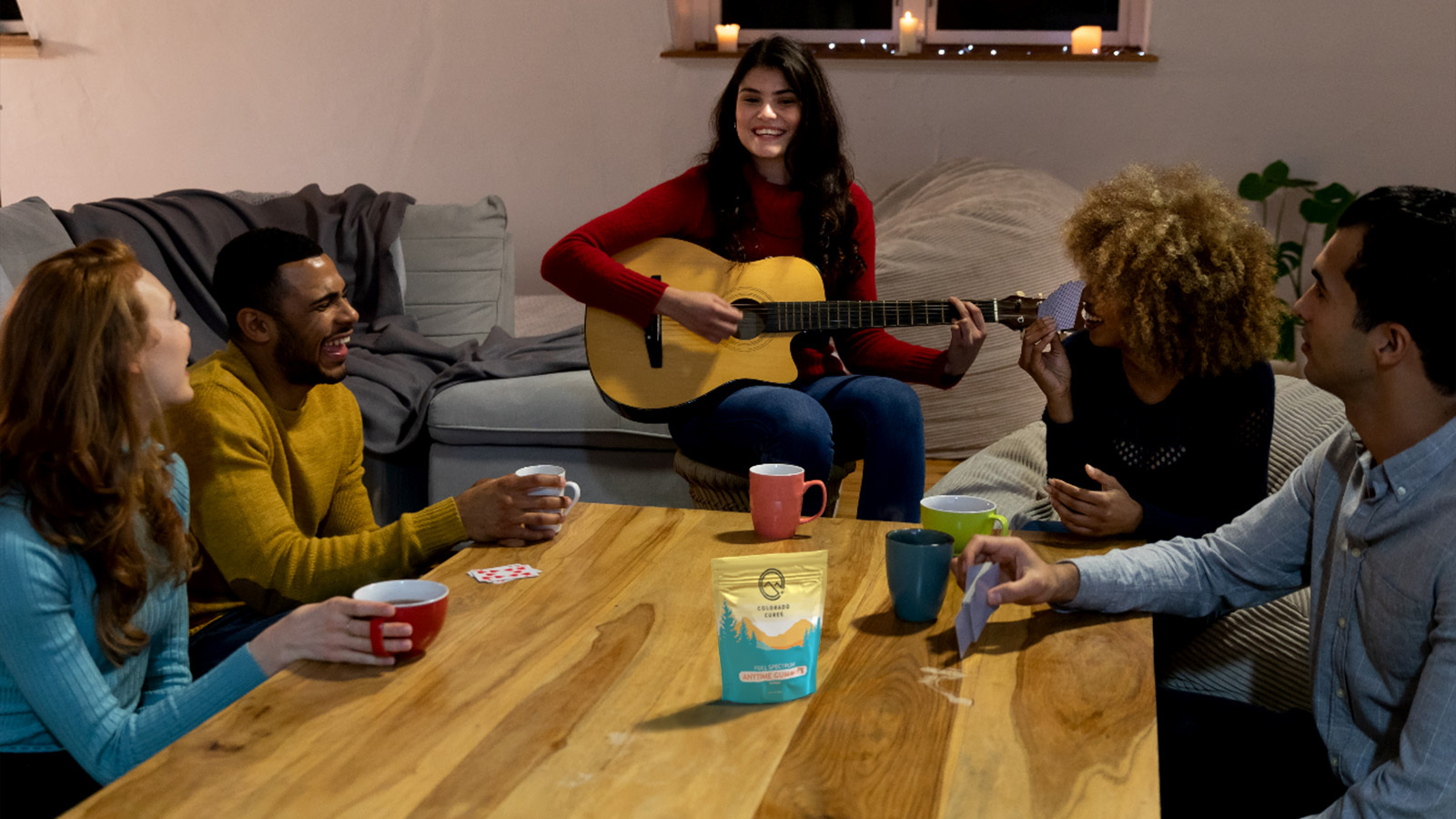 a group of friends play cards around a low table